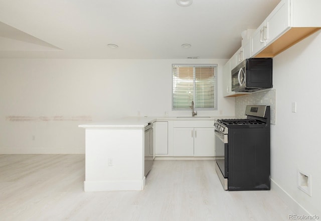 kitchen with white cabinetry, sink, appliances with stainless steel finishes, and light hardwood / wood-style flooring