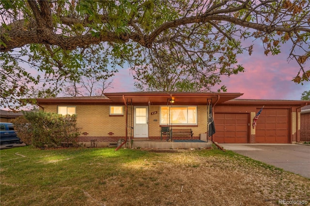 ranch-style home with brick siding, a garage, driveway, and a front lawn