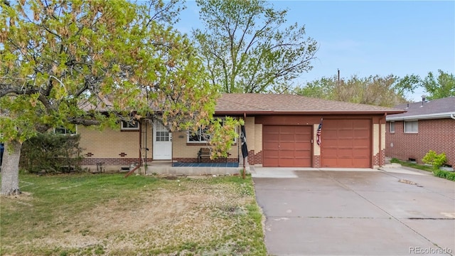 single story home featuring brick siding, a garage, driveway, and a front yard