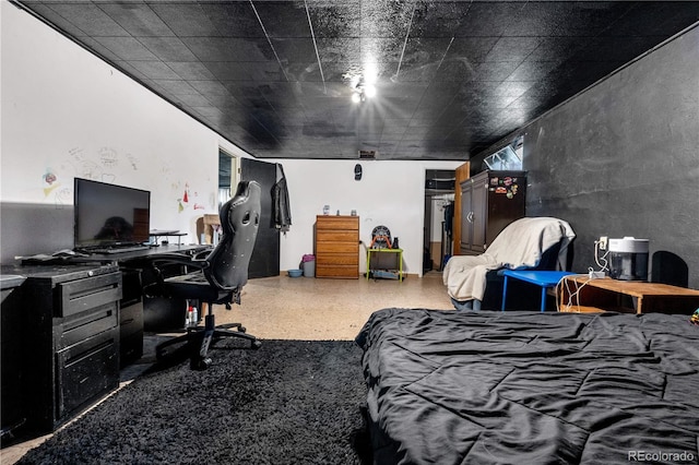 bedroom featuring a desk and speckle patterned floor