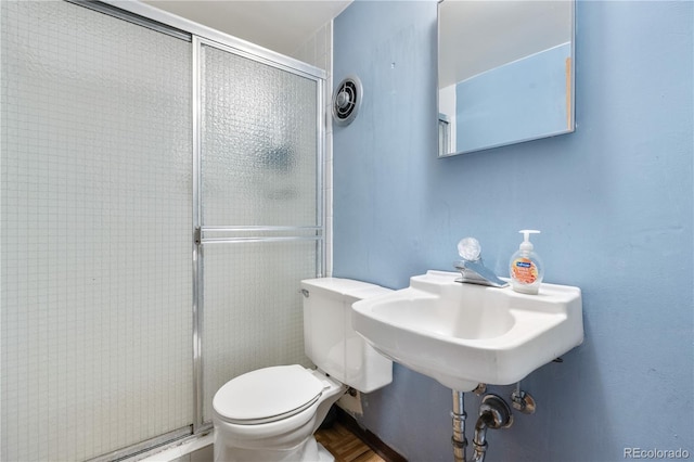 bathroom featuring a stall shower and toilet