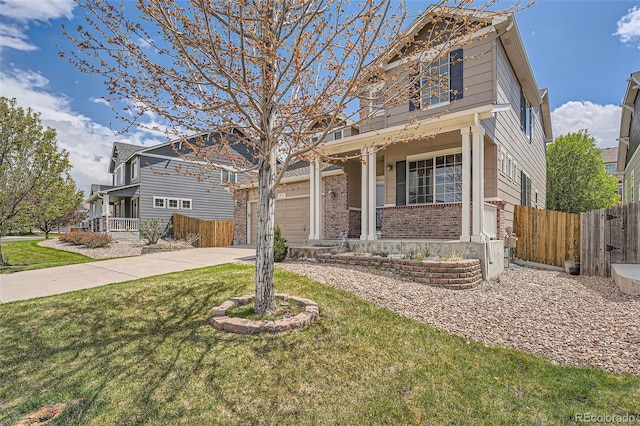 4037 S Odessa Cir, Aurora, CO 80013 - view of front facade with a porch, driveway, a front yard, brick siding, and fence
