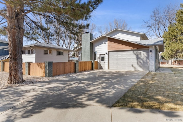 view of home's exterior with a garage, concrete driveway, fence, and a chimney