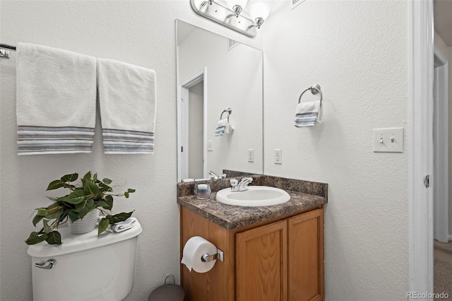 half bathroom with vanity and toilet