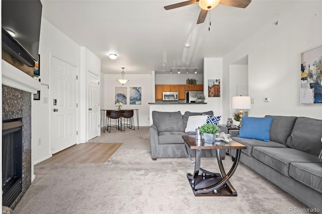 4451 S Ammons St Unit 4-203, Littleton, CO 80123 - living room featuring light colored carpet, a fireplace, ceiling fan, and rail lighting