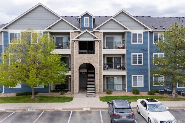 4451 S Ammons St Unit 4-203, Littleton, CO 80123 - view of building exterior with uncovered parking and central air condition unit