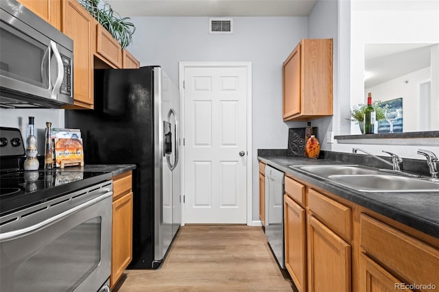 4451 S Ammons St Unit 4-203, Littleton, CO 80123 - kitchen with appliances with stainless steel finishes, light wood-style flooring, and dark countertops