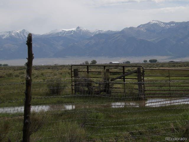 view of gate featuring a rural view and a water and mountain view