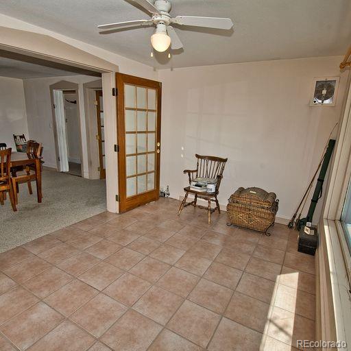 sitting room featuring french doors, light colored carpet, and ceiling fan