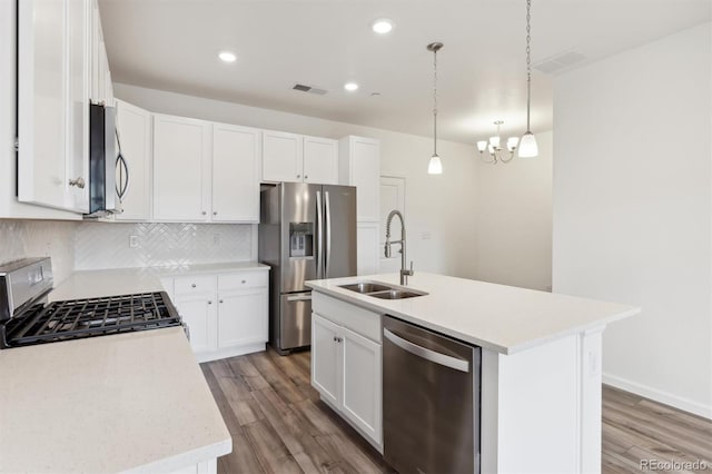 kitchen with sink, a kitchen island with sink, white cabinetry, and appliances with stainless steel finishes