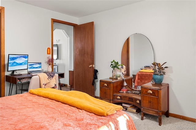 bedroom with arched walkways, carpet flooring, and baseboards