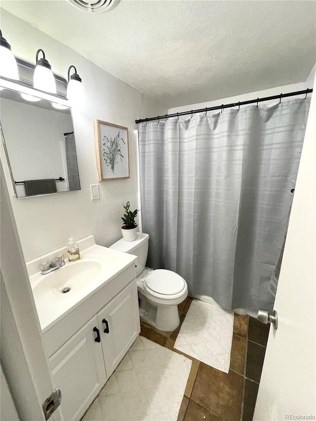 full bath with toilet, curtained shower, a textured ceiling, and vanity