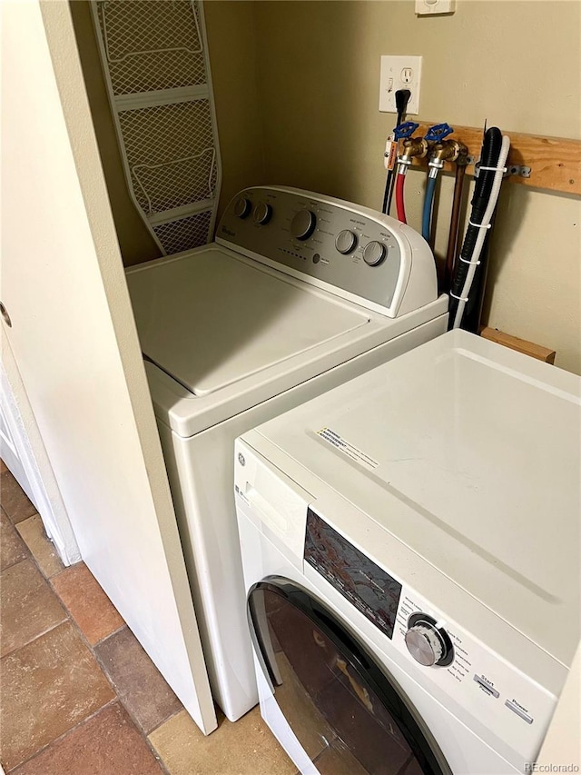 washroom featuring laundry area, stone tile flooring, and independent washer and dryer