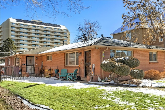 snow covered property with brick siding