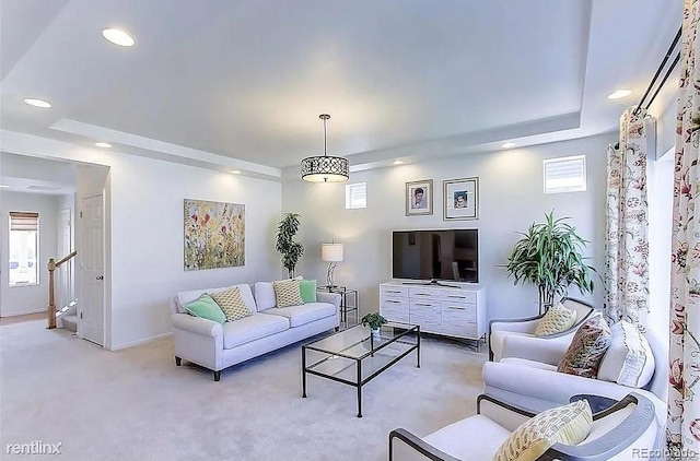 carpeted living room featuring a tray ceiling