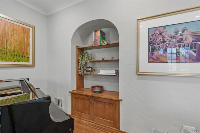 interior space with wood finished floors and visible vents