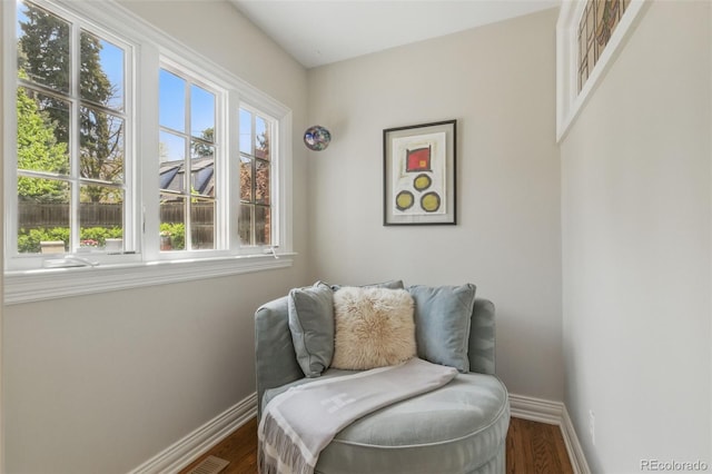 living area featuring baseboards and dark wood finished floors