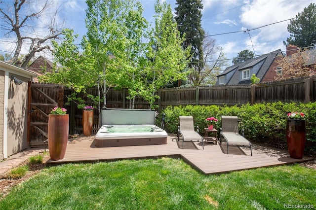 view of yard featuring hot tub deck surround, a fenced backyard, and a deck