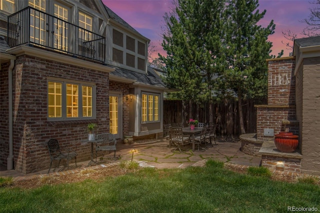 view of patio / terrace featuring fence and a balcony