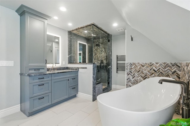 full bath featuring a freestanding tub, vaulted ceiling, a shower stall, vanity, and recessed lighting