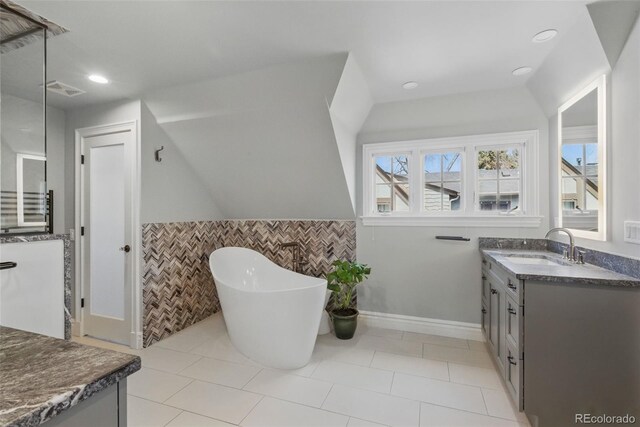 350 Albion St, Denver, CO 80220 - bathroom with wainscoting, vanity, tile patterned floors, tile walls, and a soaking tub