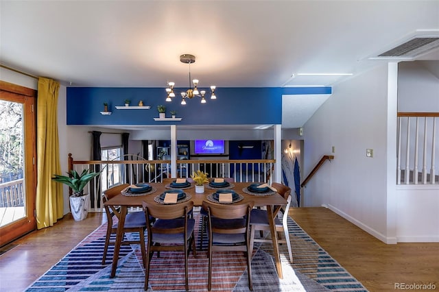 dining space with an inviting chandelier and hardwood / wood-style flooring