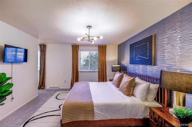 carpeted bedroom featuring a textured ceiling and a chandelier