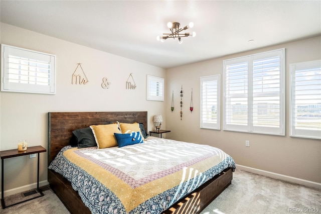 bedroom with light colored carpet and an inviting chandelier