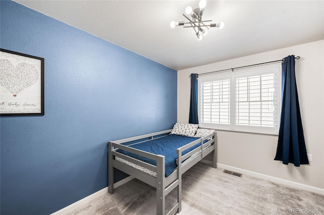 bedroom with a notable chandelier and carpet floors