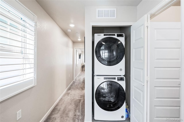 laundry area featuring carpet flooring and stacked washer and dryer