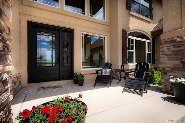 19735 Knights Xing, Monument, CO 80132 - property entrance with stucco siding, stone siding, and a patio area
