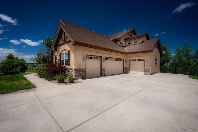 19735 Knights Xing, Monument, CO 80132 - view of property exterior featuring stone siding, a garage, stucco siding, and driveway