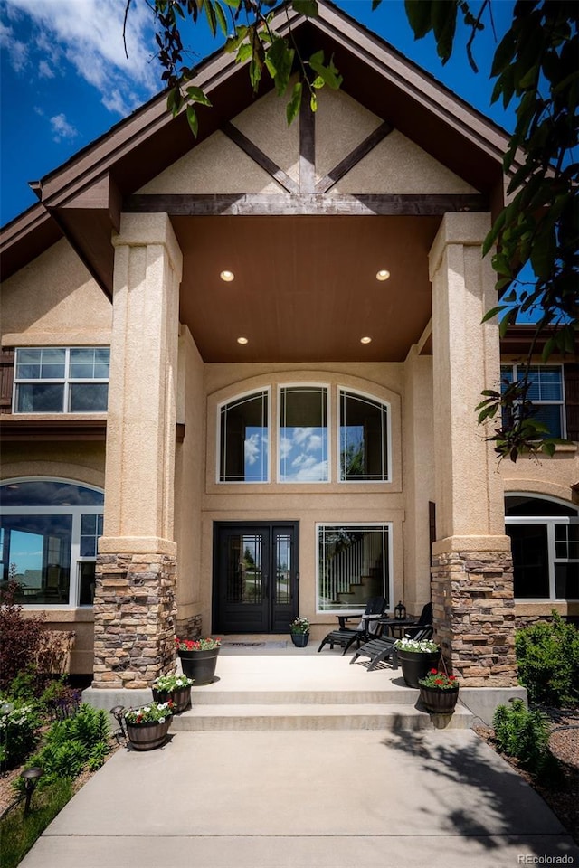 19735 Knights Xing, Monument, CO 80132 - doorway to property featuring stone siding, stucco siding, french doors, and a patio