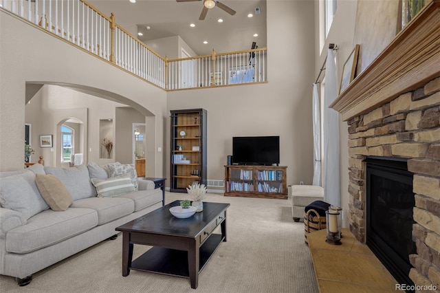 19735 Knights Xing, Monument, CO 80132 - living room featuring ceiling fan, a towering ceiling, a stone fireplace, arched walkways, and recessed lighting