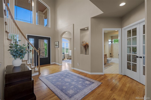 19735 Knights Xing, Monument, CO 80132 - entrance foyer with french doors, arched walkways, stairway, and wood finished floors