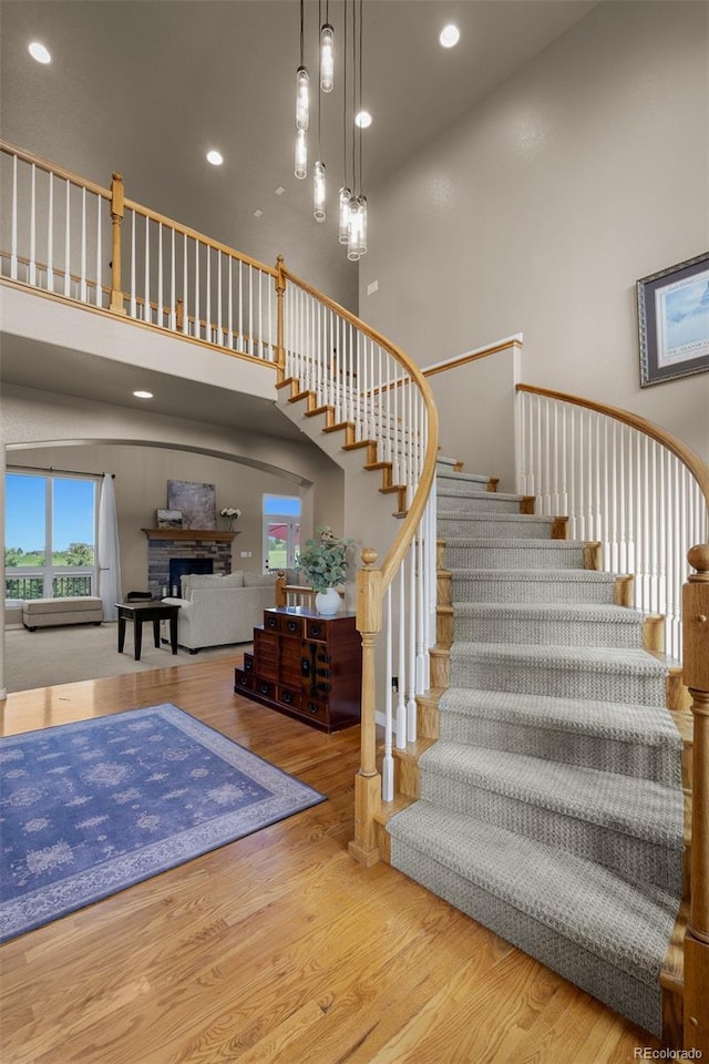 19735 Knights Xing, Monument, CO 80132 - stairway with a towering ceiling, a fireplace, wood finished floors, and recessed lighting