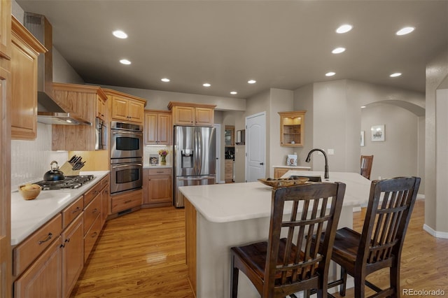 19735 Knights Xing, Monument, CO 80132 - kitchen with stainless steel appliances, arched walkways, light countertops, decorative backsplash, and a breakfast bar area