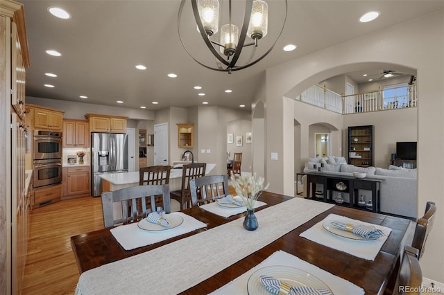 19735 Knights Xing, Monument, CO 80132 - dining area featuring arched walkways, light wood finished floors, a chandelier, ceiling fan, and recessed lighting