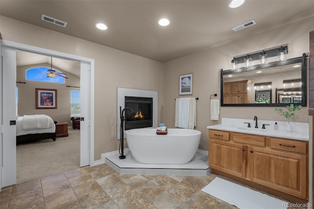 19735 Knights Xing, Monument, CO 80132 - full bath with vanity, ensuite bathroom, a soaking tub, a lit fireplace, and recessed lighting