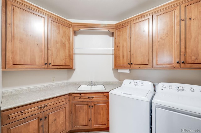 clothes washing area featuring a sink, cabinet space, and washing machine and dryer