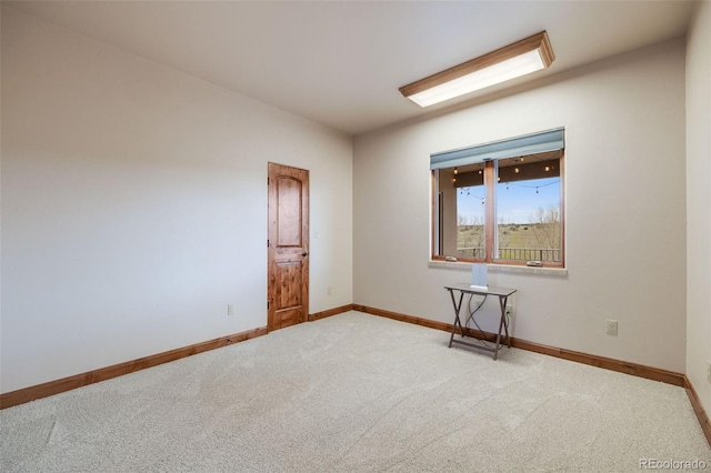 carpeted spare room featuring baseboards