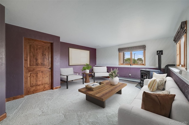 carpeted living room featuring baseboards, a wood stove, and a baseboard radiator