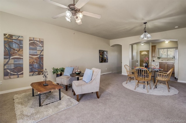 1447 Madison Ridge Hts, Colorado Springs, CO 80904 - living area featuring arched walkways, carpet flooring, ceiling fan, and baseboards