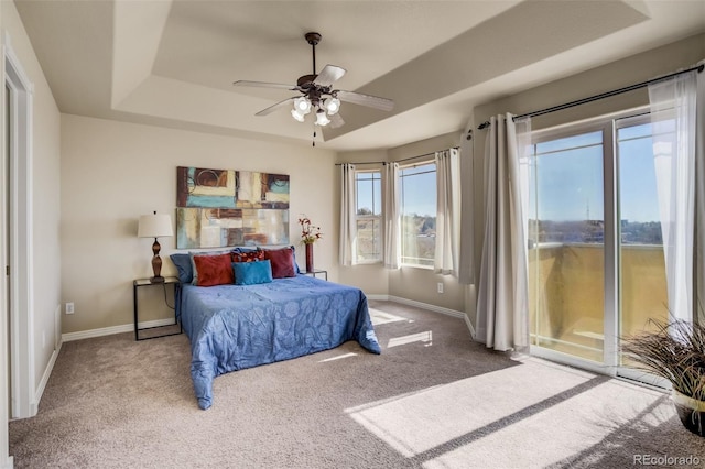 1447 Madison Ridge Hts, Colorado Springs, CO 80904 - carpeted bedroom with access to exterior, baseboards, a tray ceiling, and a ceiling fan