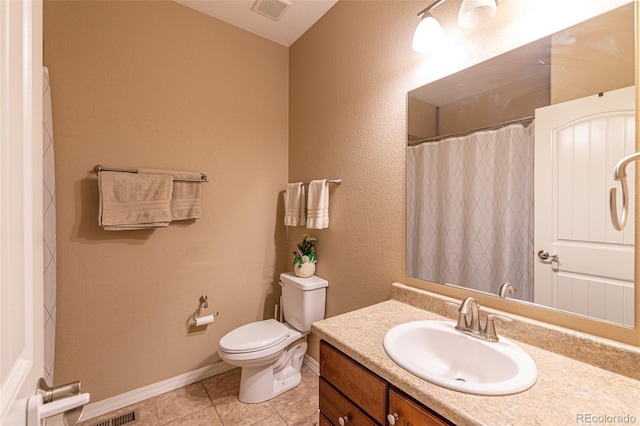 bathroom featuring tile patterned flooring, vanity, and toilet