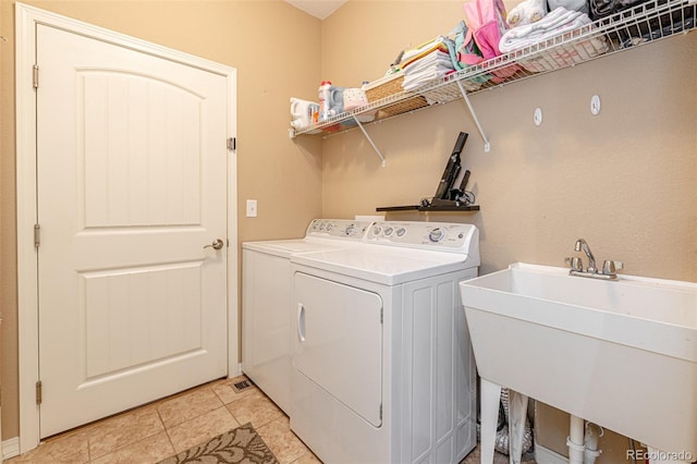 laundry room featuring light tile patterned floors, sink, and washer and clothes dryer