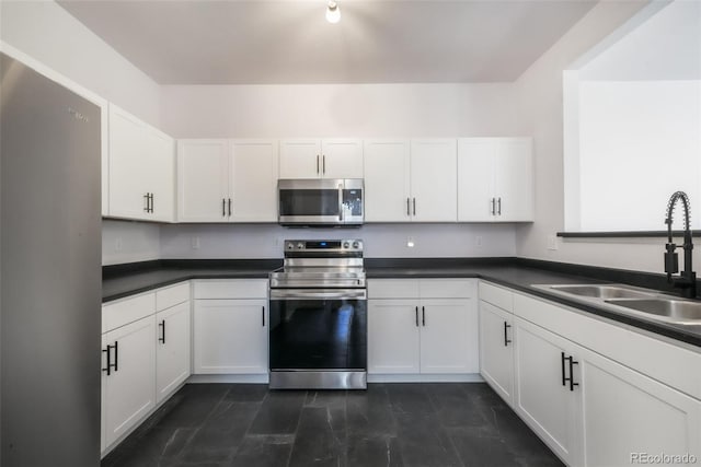kitchen with stainless steel appliances, a sink, and white cabinetry