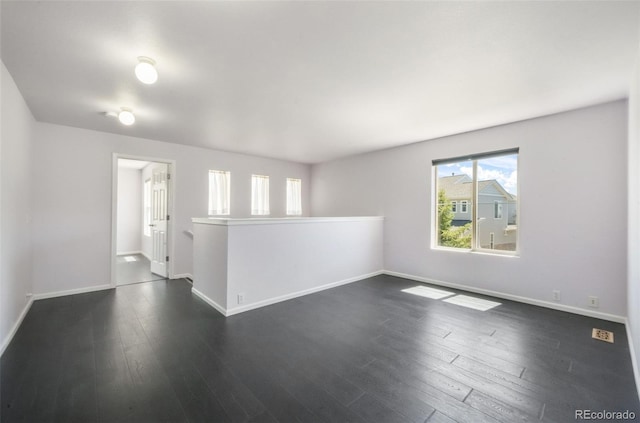 empty room with plenty of natural light and baseboards