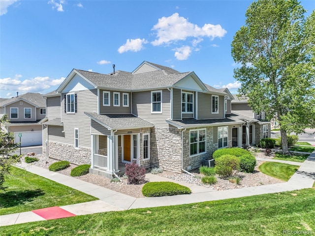 view of front of home with stone siding, a front yard, roof with shingles, and central AC