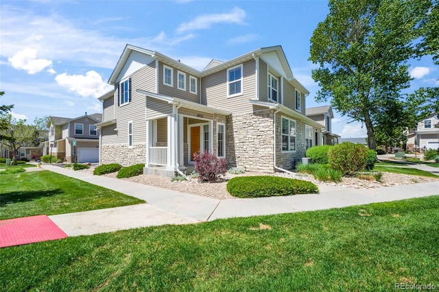 view of front of home with stone siding, a front yard, and covered porch